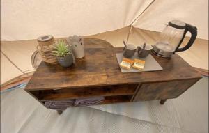 einem Holztisch mit Tassen und einem Mixer darauf in der Unterkunft Bell Tents at Llanfair Hall in Llanfairpwllgwyngyll