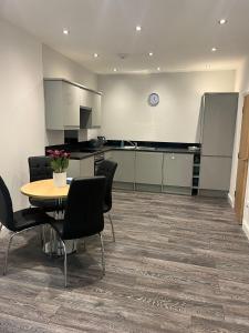 una cucina e una sala da pranzo con tavolo e sedie di Contemporary apartment Great Location with private carpark a Keighley