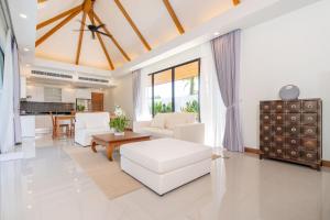 sala de estar con sofá blanco y mesa en Escape Villas - Luxury Pool Villa at Anchan Villas en Ban Phru Champa