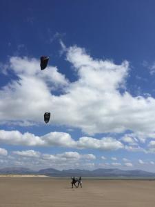 two people are flying kites on the beach at Bell Tents at Llanfair Hall in Llanfairpwllgwyngyll