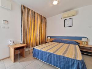a bedroom with a bed and a table and a window at Di Mare Holiday Village in Kranevo +37 photos