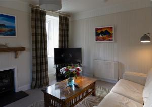 a living room with a couch and a coffee table at Duart Cottage in Glencoe