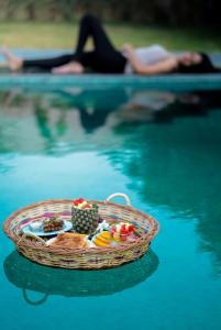 Parijat Private Pool Villa 1, 2 and 3 BHK في أودايبور: سلة من الطعام في الماء بجوار حمام السباحة
