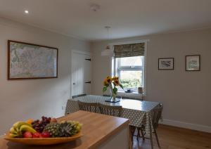 a kitchen with a bowl of fruit on a table at Duart Cottage in Glencoe +14 photos