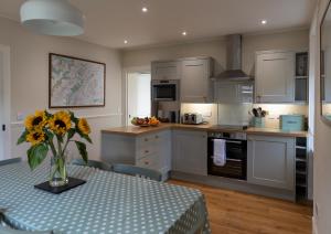 uma cozinha com uma mesa com um vaso de flores em Duart Cottage em Glencoe