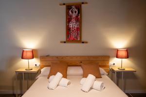 a bedroom with a bed with two lamps on both sides at Apartamentos Doña Concha in Seville