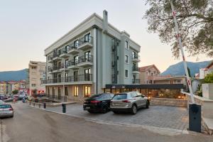 un edificio con coches estacionados en un estacionamiento en Hotel Diplomat en Budva
