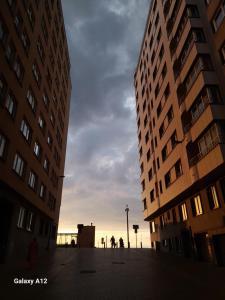 un coucher de soleil entre deux grands bâtiments d'une ville dans l'établissement App Seaview Albert I, à Ostende