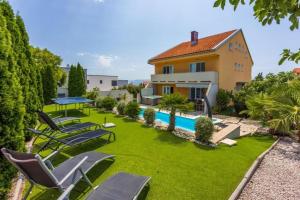 een afbeelding van een achtertuin met stoelen en een zwembad bij House Moderna 2 in Crikvenica
