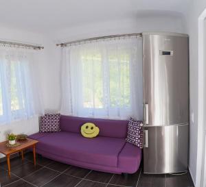 a purple couch in a living room with a refrigerator at Carla House in Vidolm