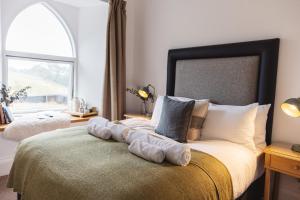 una camera da letto con un grande letto con una grande finestra di Isle of Raasay Distillery a Raasay