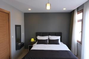 Schlafzimmer mit einem schwarzen und weißen Bett und einem Fenster in der Unterkunft Ore Pera Suites in Istanbul