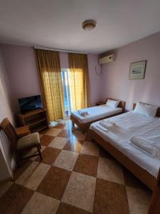 a hotel room with two beds and a television at Apartment FLORA in Bregvija