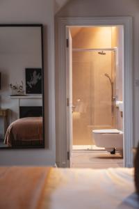 een badkamer met een douche, een wastafel en een spiegel bij Isle of Raasay Distillery in Raasay
