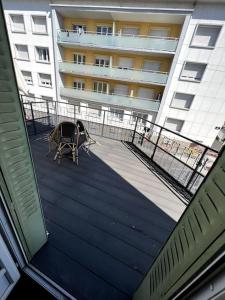 - un balcon d'un immeuble avec une table et des chaises dans l'établissement Superbe Appartement lumineux proche tramway, à Clermont-Ferrand