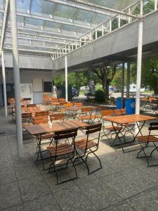 AllYouNeed Oktoberfest Basic Camping في ميونخ: مجموعة طاولات وكراسي تحت مبنى
