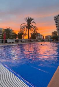 une grande piscine avec un coucher de soleil en arrière-plan dans l'établissement Brisa Marina, à Las Canteras