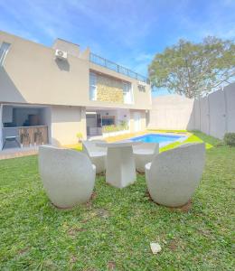 ein Haus mit einem Tisch und Stühlen im Hof in der Unterkunft Armada Resort Puncak in Sampal 2