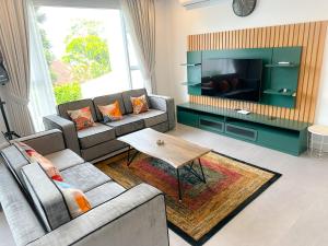 a living room with two couches and a tv at Armada Resort Puncak in Sampal 2