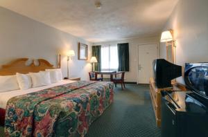 a hotel room with a bed and a television at Americas Best Value Inn Uvalde in Uvalde +27 photos