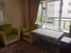 een kamer met 2 stoelen, een tafel en een raam bij Furnished rooms for students and youth in Sivas