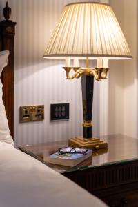a lamp on a table next to a bed at Powerscourt Hotel, Autograph Collection in Enniskerry