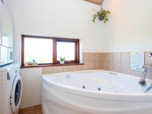 baño con bañera blanca grande y ventanas en 8 person holiday home in Ulfborg en Thorsminde