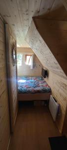 a small room with a bed in a wooden cabin at Cabane Féerique in Laives