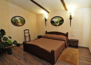 een slaapkamer met een bed en twee foto's aan de muur bij ЕДБУРГ Готельно-ресторанний комплекс in Nizhnedneprovsk