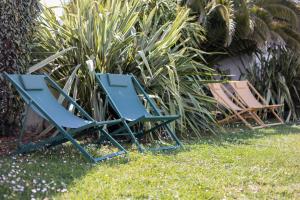 deux chaises de pelouse bleues assises dans l'herbe dans l'établissement Appart'hotel Perle de Ré, à La Couarde-sur-Mer