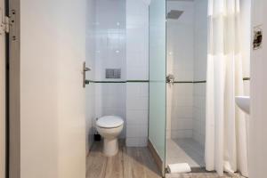 ein Bad mit einem WC und einer Glasdusche in der Unterkunft HOSTAL BEDMATES in Barcelona