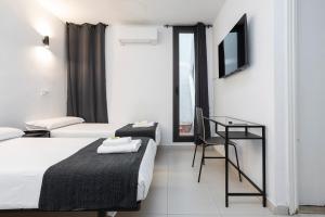 a hotel room with two beds and a desk at HOSTAL BEDMATES in Barcelona +248 photos
