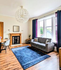 a living room with a couch and a chandelier at Balmoral Villa, Oban in Oban