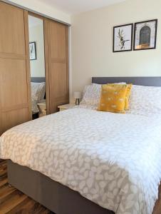 a bedroom with a large bed with yellow pillows at Balmoral Villa, Oban in Oban