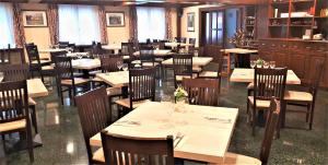 a dining room with tables and chairs in a restaurant at Hotel Urogallo in Vielha