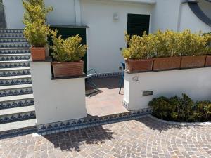 um pátio com vasos de plantas ao lado de um edifício em IL SOFFIO DI TIFEO - RESORT em Ischia