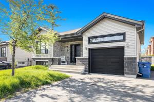 a house with a garage door and a tree at Beautiful Room 4mins from Gatineau-Ottawa Airport in Gatineau