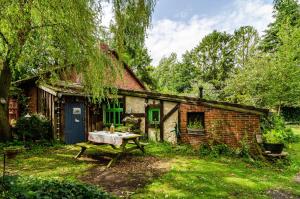 een oud bakstenen huis met een picknicktafel ervoor bij Fairy Cottage in Rhauderfehn