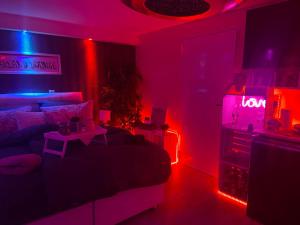 格斯塔特的住宿－Thailand Lounge Whirlpool Sauna SPA，一间设有床铺的房间和一间带 ⁇ 虹灯的房间