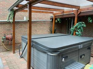 a barbecue under a pergola on a patio at Thailand Lounge Whirlpool Sauna SPA in Geesthacht