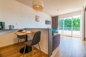 a kitchen and living room with a table and chairs at CERISE Dax - Les Jardins du Lac in Saint-Paul-lès-Dax