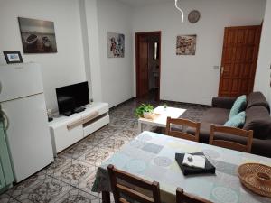 uma sala de estar com um sofá, uma mesa e uma televisão em Orzola frente al mar em Orzola