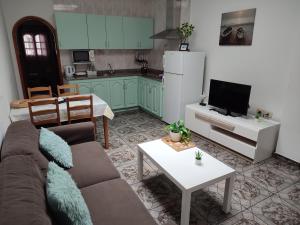 uma sala de estar com um sofá, uma mesa e uma cozinha em Orzola frente al mar em Orzola