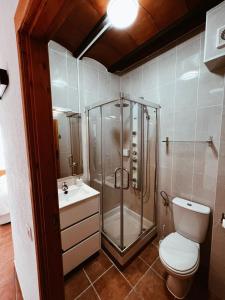 een badkamer met een douche, een toilet en een wastafel bij Casa Cardona in Móra d'Ebre