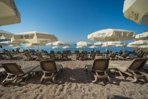 蘇托莫雷的住宿－薩托酒店，海滩上的一组椅子和遮阳伞