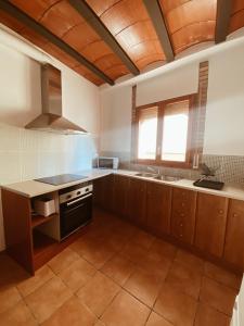 een keuken met houten kasten en een houten plafond bij Casa Cardona in Móra d'Ebre