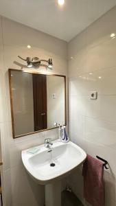 y baño con lavabo blanco y espejo. en HABITACIÓN DOBLE (DOS CAMAS) EN CENTRO HISTÓRICO, en Cartagena