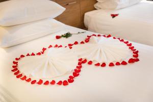 Una cama blanca con un pastel en forma de corazón. en Virgo Hotel Nha Trang, en Nha Trang