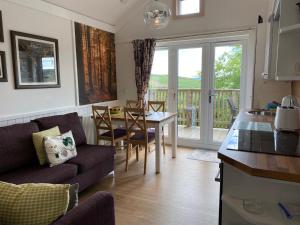 a kitchen and living room with a table and chairs at Badger Lodge with Hot Tub in Cupar