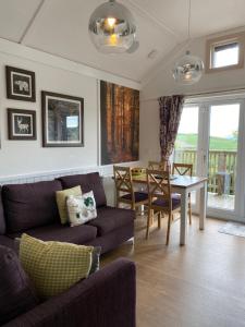 a living room with a couch and a table at Badger Lodge with Hot Tub in Cupar +16 photos